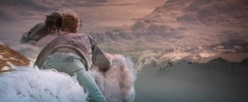 Movie still from “The NeverEnding Story” (1984), directed by Wolfgang Petersen – A woman is standing in front of a snowy mountain; Wide shot, High angle