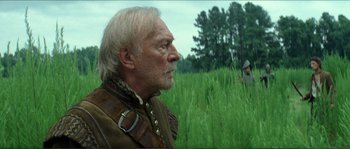 Movie still from “The New World” (2005), directed by Terrence Malick – An older man in a field looking to his left; Medium shot, Over the shoulder angle