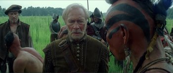 Movie still from “The New World” (2005), directed by Terrence Malick – An old man with a beard in a field with other men; Medium shot, Over the shoulder angle