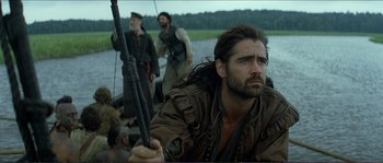 Movie still from “The New World” (2005), directed by Terrence Malick – A man with a long beard holding onto a pole; Medium shot, Low angle