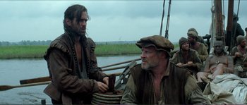 Movie still from “The New World” (2005), directed by Terrence Malick – Two men sitting on a boat in the water; Medium shot, Low angle