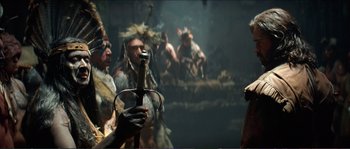 Movie still from “The New World” (2005), directed by Terrence Malick – A group of native american men standing next to each other; Medium shot, Over the shoulder angle