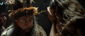 Movie still from “The New World” (2005), directed by Terrence Malick – A man in a native american costume looking in a mirror; Close Up shot, Over the shoulder angle