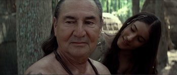 Movie still from “The New World” (2005), directed by Terrence Malick – An older man with long hair and a necklace; Close Up shot, Over the shoulder angle