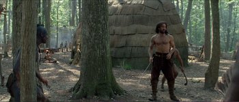 Movie still from “The New World” (2005), directed by Terrence Malick – A man standing next to a large tree; Wide shot, Low angle