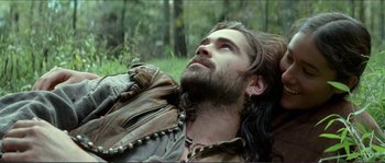 Movie still from “The New World” (2005), directed by Terrence Malick – A man with long hair is laying down in the grass; Close Up shot, Low angle