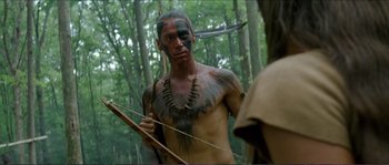 Movie still from “The New World” (2005), directed by Terrence Malick – A man with a painted face holding a bow and arrow; Close Up shot, Over the shoulder angle