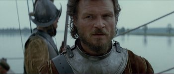 Movie still from “The New World” (2005), directed by Terrence Malick – A person wearing armor and a sword; Close Up shot, Over the shoulder angle