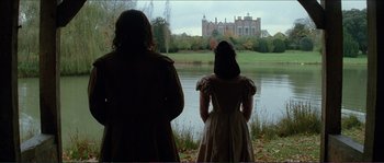 Movie still from “The New World” (2005), directed by Terrence Malick – Two women standing near a body of water looking at a castle; Wide shot, Low angle