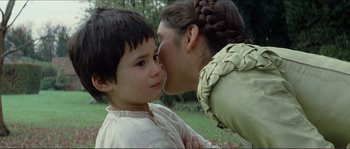 Movie still from “The New World” (2005), directed by Terrence Malick – A young boy kissing a woman on the side of his face; Close Up shot, Over the shoulder angle