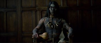 Movie still from “The New World” (2005), directed by Terrence Malick – A man in a costume sitting in a chair holding an object; Medium shot, Low angle