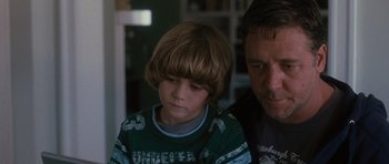 Movie still from “The Next Three Days” (2010), directed by Paul Haggis – A man and a boy sitting next to each other in a room; Close Up shot, Over the shoulder angle