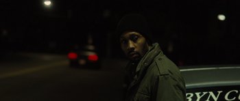Movie still from “The Next Three Days” (2010), directed by Paul Haggis – A man standing in the dark near a street; Close Up shot, Over the shoulder angle