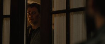 Movie still from “The Next Three Days” (2010), directed by Paul Haggis – A man standing next to a window in a room; Close Up shot, Over the shoulder angle