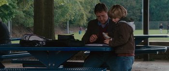 Movie still from “The Next Three Days” (2010), directed by Paul Haggis – A man sitting at a table with a child; Medium shot, Over the shoulder angle