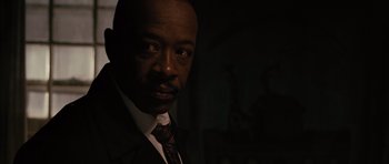 Movie still from “The Next Three Days” (2010), directed by Paul Haggis – A man wearing a suit and tie in the dark; Close Up shot, Over the shoulder angle