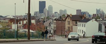 Movie still from “The Next Three Days” (2010), directed by Paul Haggis – Two people walking down a street with a city in the background; Extreme Wide shot, High angle