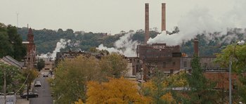 Movie still from “The Next Three Days” (2010), directed by Paul Haggis – A factory that has smoke coming out of it's chimney; Extreme Wide shot, High angle