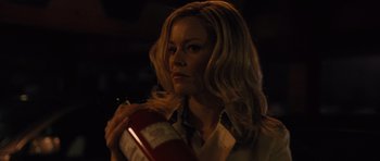 Movie still from “The Next Three Days” (2010), directed by Paul Haggis – A woman holding onto a fire extinguisher in a dark room; Close Up shot, Over the shoulder angle