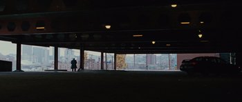 Movie still from “The Next Three Days” (2010), directed by Paul Haggis – A person standing under a bridge looking out at a city skyline; Extreme Wide shot, High angle