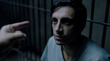 Movie still from “The Night Of” (2016), directed by James Marsh – A man in a jail cell with his hand up to his face; Close Up shot, High angle