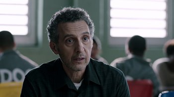 Movie still from “The Night Of” (2016), directed by James Marsh – A person sitting in front of a window; Close Up shot, Over the shoulder angle