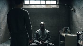 Movie still from “The Night Of” (2016), directed by James Marsh – A man sitting in front of another man in a jail cell; Medium shot, Over the shoulder angle