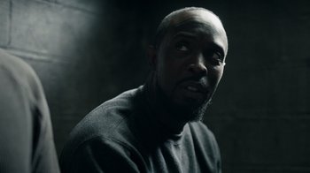 Movie still from “The Night Of” (2016), directed by James Marsh – A man with a beard is looking at the camera; Close Up shot, Over the shoulder angle
