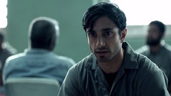 Movie still from “The Night Of” (2016), directed by James Marsh – A man sitting in front of another man in a room; Close Up shot, Over the shoulder angle