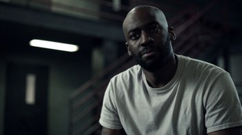 Movie still from “The Night Of” (2016), directed by James Marsh – A man in a white t - shirt is looking at the camera; Close Up shot, Low angle