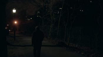 Movie still from “The Night Of” (2016), directed by James Marsh – A man standing on the side of a road at night; Extreme Wide shot, Over the shoulder angle
