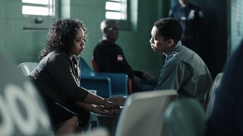 Movie still from “The Night Of” (2016), directed by James Marsh – A man and a woman talking to each other in a room; Medium shot, High angle