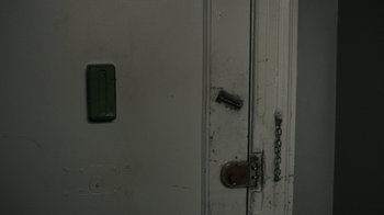 Movie still from “The Night Of” (2016), directed by James Marsh – The door of a building has a chain on it; Extreme Close Up shot, High angle