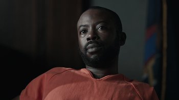 Movie still from “The Night Of” (2016), directed by James Marsh – A man in a red shirt is looking upward; Close Up shot, Low angle