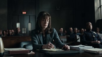 Movie still from “The Night Of” (2016), directed by James Marsh – A woman sitting at a table writing on a piece of paper; Medium shot, High angle