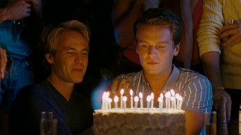 Movie still from “The Normal Heart” (2014), directed by Ryan Murphy – Two men are looking at a cake with lit candles on it; Close Up shot, Over the shoulder angle