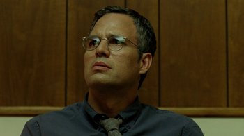 Movie still from “The Normal Heart” (2014), directed by Ryan Murphy – A man with glasses is sitting in front of a wooden wall; Close Up shot, Low angle