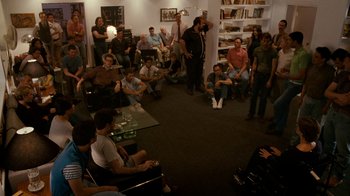 Movie still from “The Normal Heart” (2014), directed by Ryan Murphy – A group of people sitting in a room with remotes; Wide shot, High angle