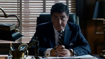 Movie still from “The Normal Heart” (2014), directed by Ryan Murphy – A man sitting at a desk in front of a pair of pens; Medium shot, Over the shoulder angle