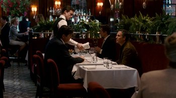Movie still from “The Normal Heart” (2014), directed by Ryan Murphy – A group of people sitting at a table with wine glasses; Wide shot, Over the shoulder angle
