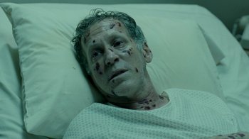 Movie still from “The Normal Heart” (2014), directed by Ryan Murphy – A man laying in a hospital bed covered in blood; Close Up shot, High angle