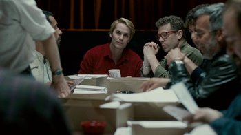 Movie still from “The Normal Heart” (2014), directed by Ryan Murphy – A group of people sitting at a table with papers; Medium shot, Over the shoulder angle