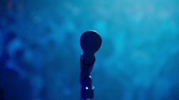 Movie still from “The Normal Heart” (2014), directed by Ryan Murphy – A microphone on a blue background; Extreme Close Up shot, Overhead angle