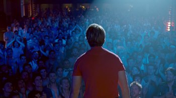 Movie still from “The Normal Heart” (2014), directed by Ryan Murphy – A man standing in front of a crowd of onlookers; Wide shot, Over the shoulder angle