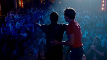 Movie still from “The Normal Heart” (2014), directed by Ryan Murphy – Two men standing in front of a crowd of onlookers; Wide shot, Over the shoulder angle