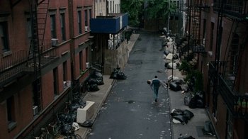 Movie still from “The Normal Heart” (2014), directed by Ryan Murphy – A man walking down a street with garbage on the ground; Extreme Wide shot, High angle