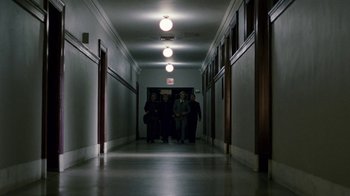 Movie still from “The Normal Heart” (2014), directed by Ryan Murphy – Three people are walking down a long hallway at night; Extreme Wide shot, Low angle