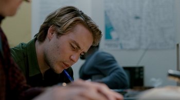 Movie still from “The Normal Heart” (2014), directed by Ryan Murphy – A young man writing on a paper with a blue pen; Close Up shot, Over the shoulder angle