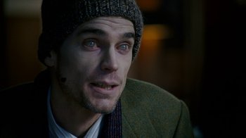 Movie still from “The Normal Heart” (2014), directed by Ryan Murphy – A person wearing a jacket and a hat; Close Up shot, Over the shoulder angle