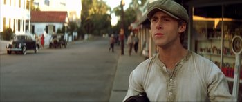 Movie still from “The Notebook” (2004), directed by Nick Cassavetes – A man wearing a hat standing on the side of the street; Close Up shot, Low angle